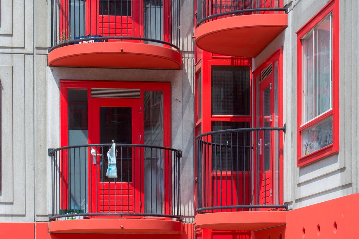 Vibrant red balconies with unique design on a modern residential building facade