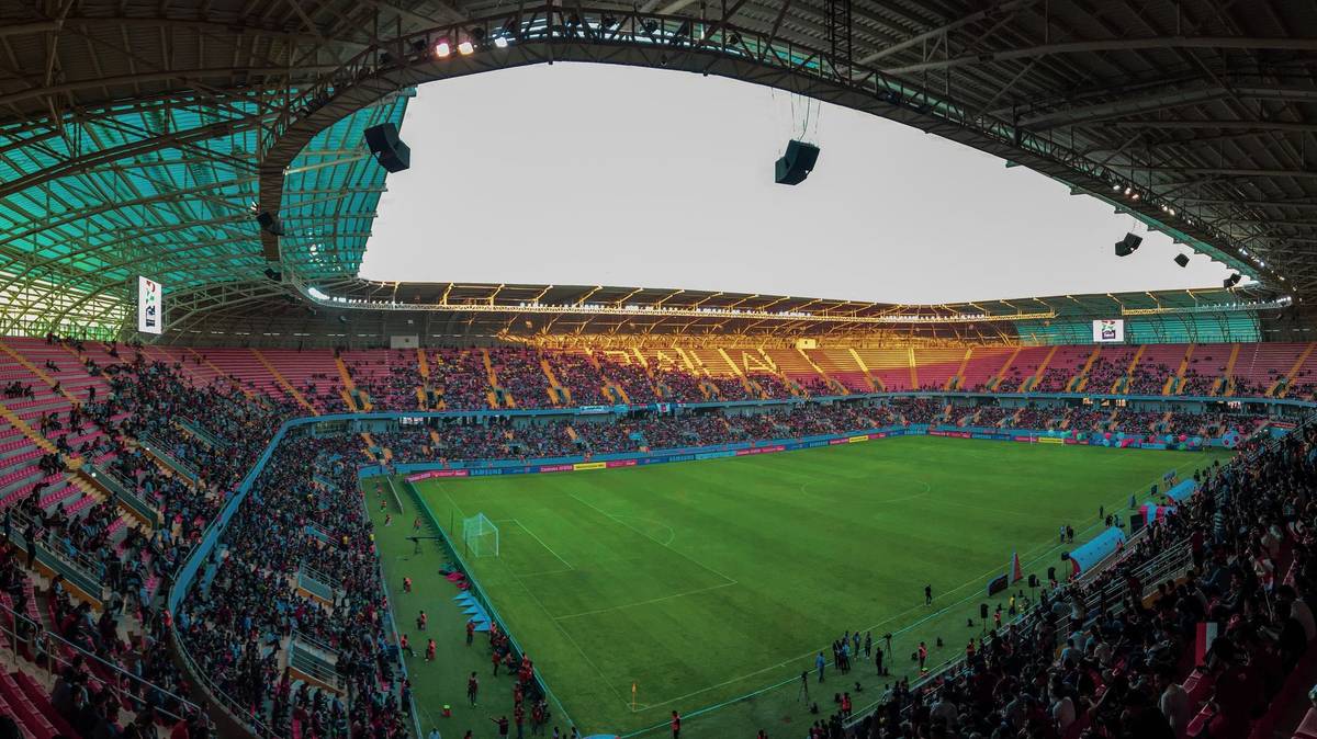 Panoramic view of a bustling soccer stadium filled with enthusiastic fans during a vibrant match.