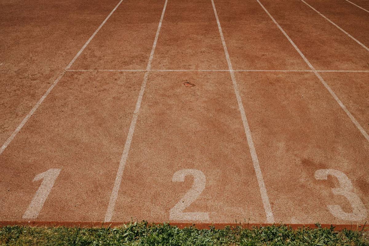An outdoor athletics track with numbered lanes.